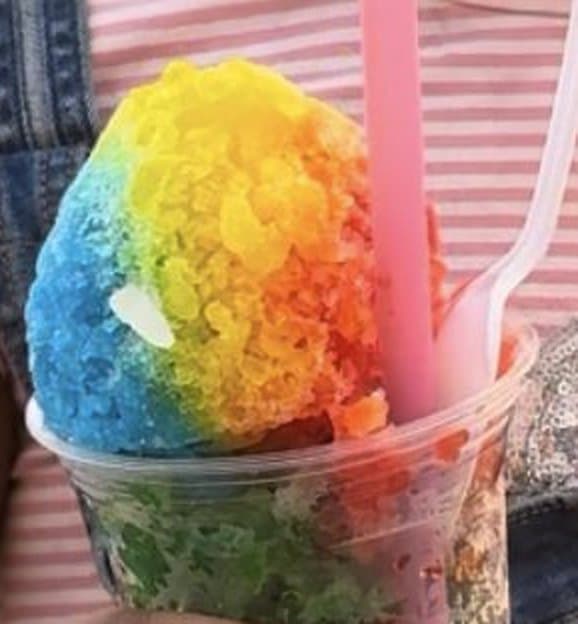 A rainbow snoball, soft and piled high above the cup